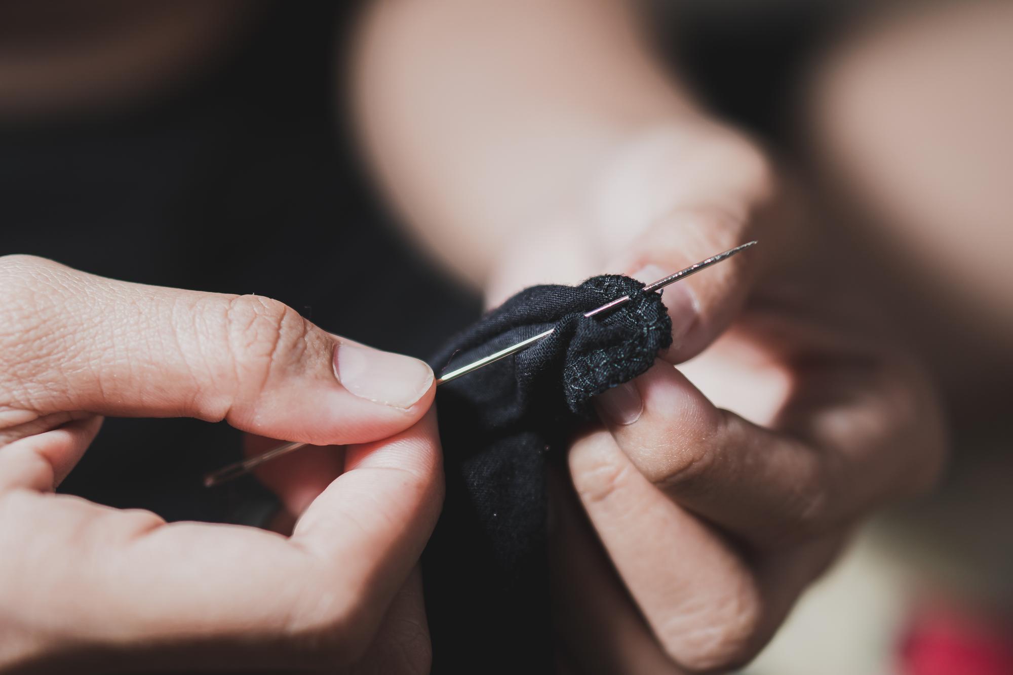 Master at work: hand guiding needle through fabric